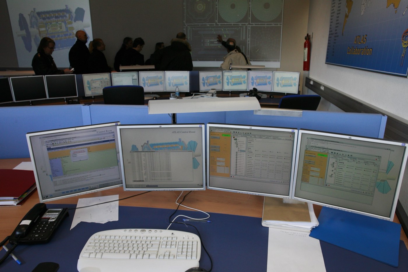 Operators at rows of monitors in a control room